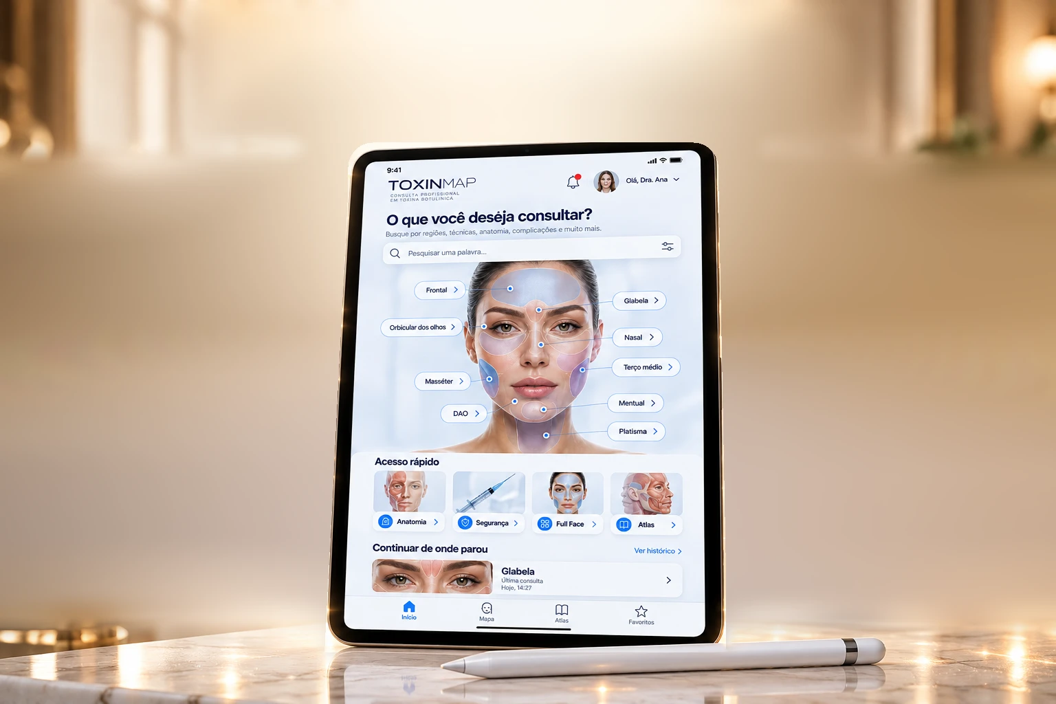 iPad sobre a mesa com a tela inicial do ToxinMap: busca, mapa facial com as regiões da face, acesso rápido e navegação; Apple Pencil à frente